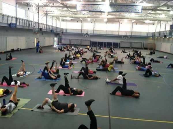 Wide shot of the gym, clients are laying down with their leg in the air