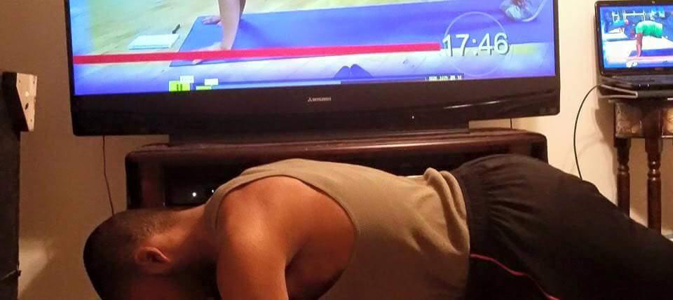 Doing pushups while watching online fitnes program