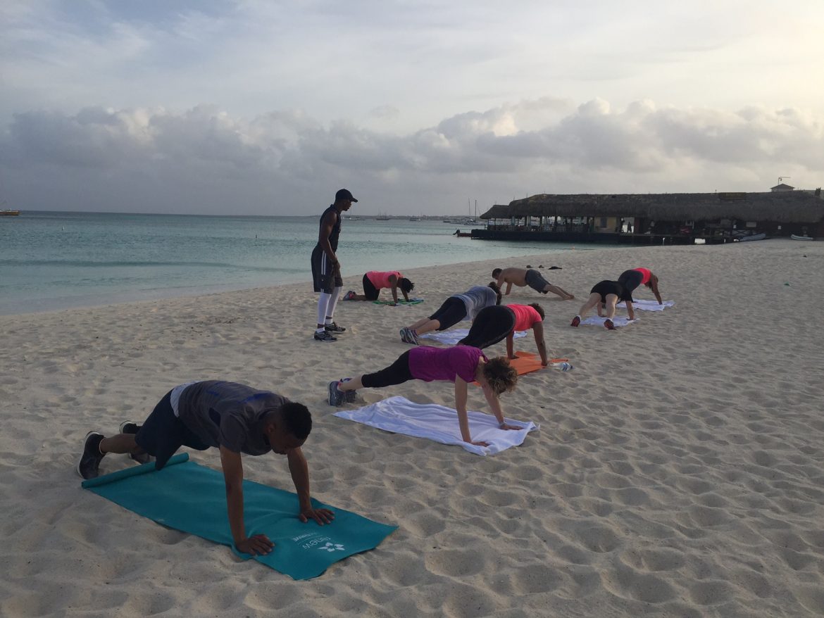 Pushups on oceanfront sands while being coached